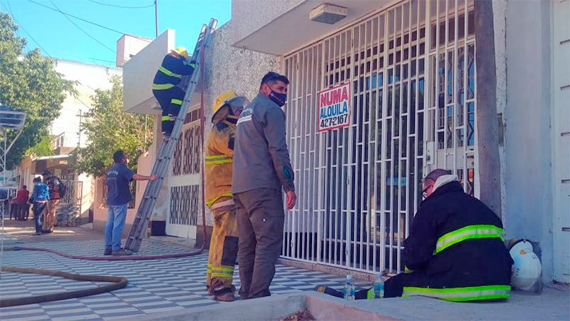 Bomberos ingresan a combatir el fuego por casas cercanas.  