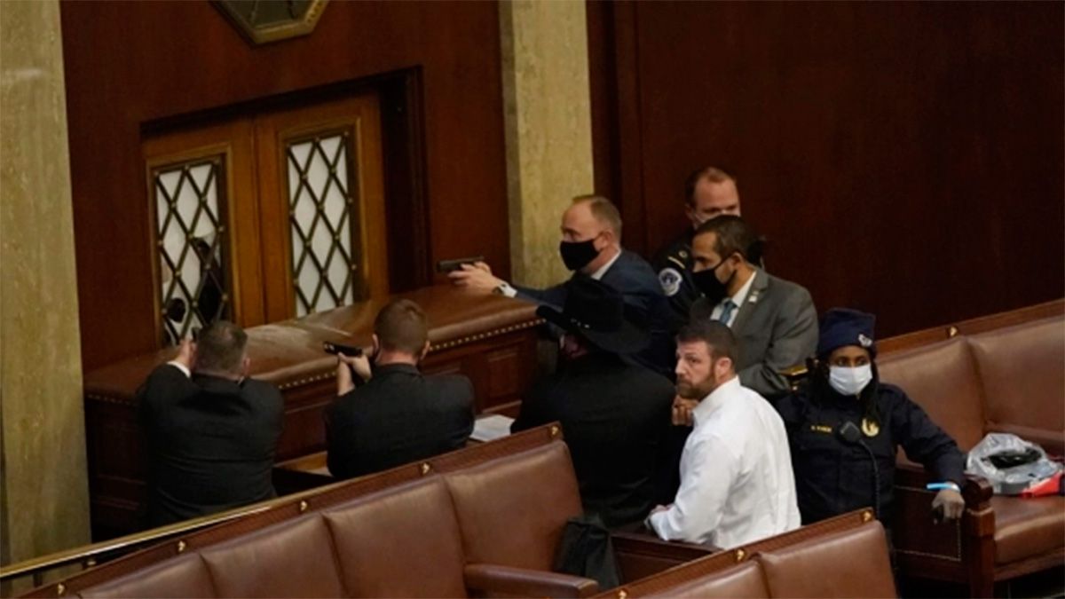 Oficiales de policía del Capitolio de EEUU apuntan sus armas a un manifestante 